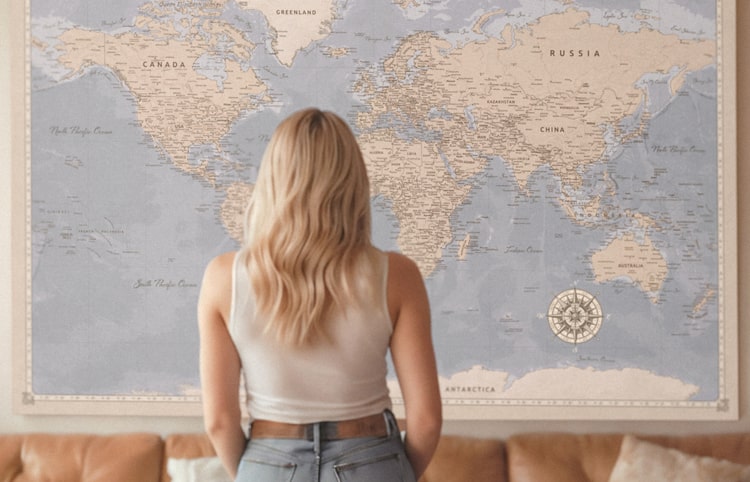 Blonde woman looking at a large personalised travel world map pinboard on the wall, perfect gift for travellers, pushpin cork board.